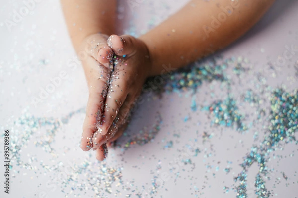 Obraz small children's hands in glitter sequins . Christmas new year holidays.