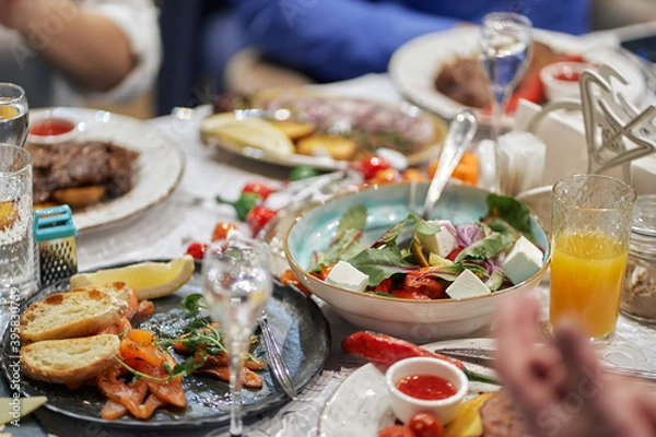 Fototapeta leftover festive table. banquet completion. half-eaten salads and snacks. alcohol and juices.