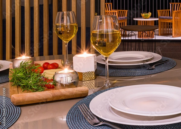 Obraz romantic dinner with candles, 2 glasses of white wine, cheese plate and cocktail tomatoes on a summer evening