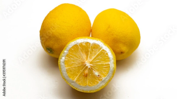 Fototapeta Two whole and a half cut fresh yellow lemon on a isolated white background.