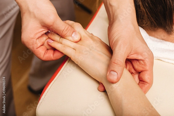 Fototapeta Massage hands and fingers at specific points, hands close-up. Relaxing massage for workers