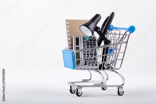 Obraz Shopping trolley with calculator, notepad and office supplies. Organization of the workplace. Business and finance concept.