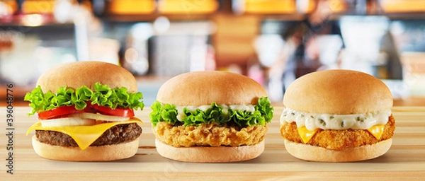 Fototapeta a beef burger chicken burger and fish burger in the wooden table with a background modern of restaurant
