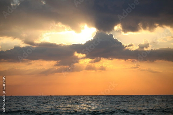 Fototapeta evening sky over the ocean overcast with thunderclouds sunset
