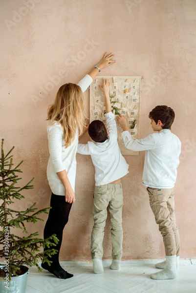 Fototapeta advent calendar hanging on the wall. gifts surprises for children. two emotional boys