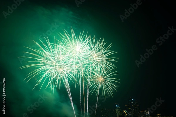 Fototapeta Firework festival with beach foreground and city background at Pattaya beach, Thailand. Colorful firework in celebration festival background