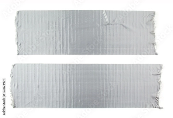 Fototapeta Two stripes of silver grey adhesive tape on white background. Torn pieces of grey sticky duct tape.