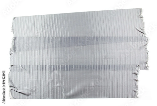 Fototapeta Torn pieces of silver grey adhesive duct tape isolated on white background.