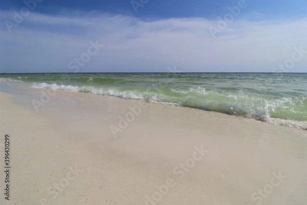 Fototapeta Close-up green wave on the ocean shore, small wave creates foam, shooting from the beach