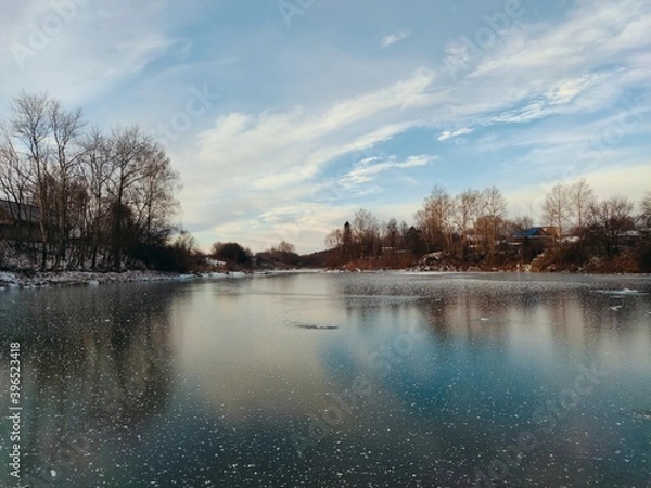 Fototapeta frozen snow covered lake surface against a blue sky with beautiful clouds