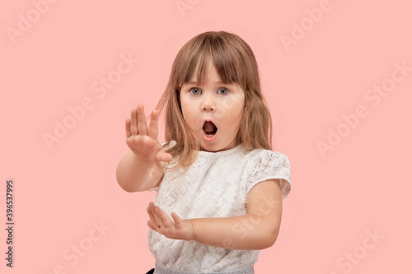 Fototapeta Little blonde girl points a no forbidden gesture, palm to the camera. Pink isolated background.