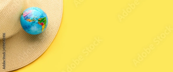 Fototapeta Tourist theme: hat, globe on a yellow background, empty space for text on the right. Travel accessories. The globe shows South America, North America, USA. Banner.