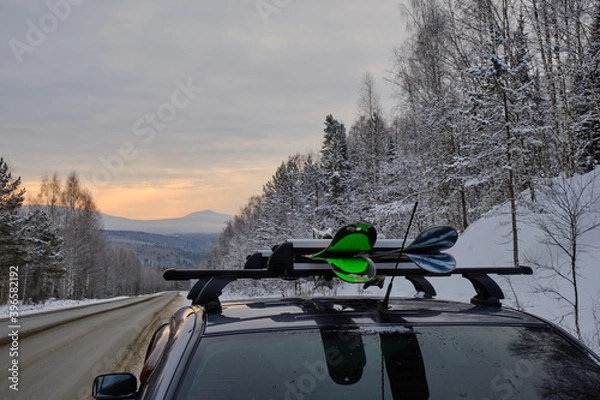 Fototapeta Roof rack of a ski and snowboard car with a mountain background in winter