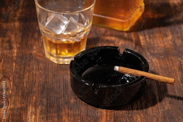 Obraz Glass of whisky and lighted cigar in an ash tray