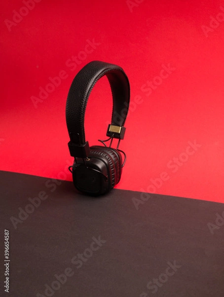 Fototapeta Classic black wired headphones on colored paper background. Retro style. 80s. Pop culture. Top view. Minimal Music Concept