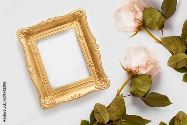Fototapeta Gold photo frame with copy space decorated with roses. The concept of beautiful backgrounds for text.