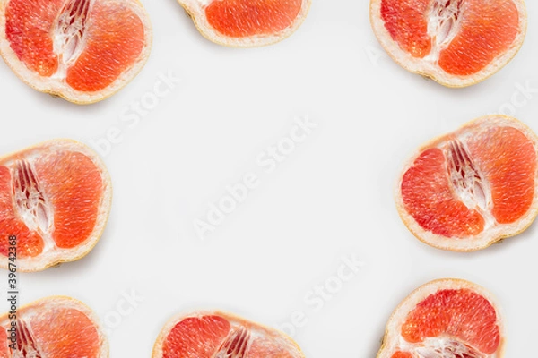 Fototapeta Grapefruit slices around the copy space. The concept of citrus vitamins or beautiful backgrounds .
