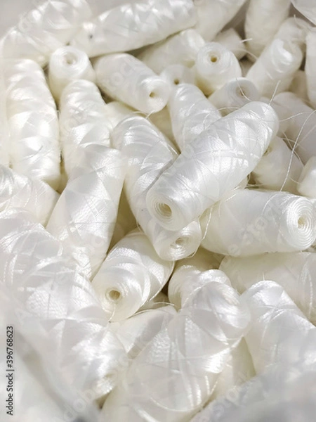 Obraz Lots of white polyester and silk threads. Sewing machine spools. Background on the theme of light industry