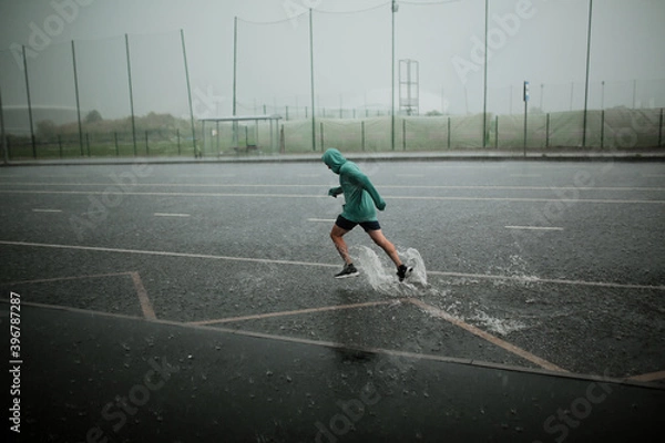 Fototapeta man runs in the rain
