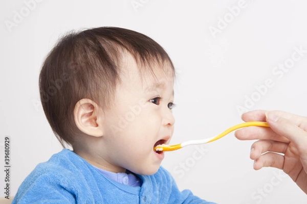 Obraz Baby eating with spoon