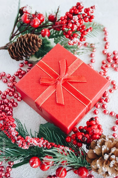 Fototapeta Red gift box, fir branches and christmas decor on a white background