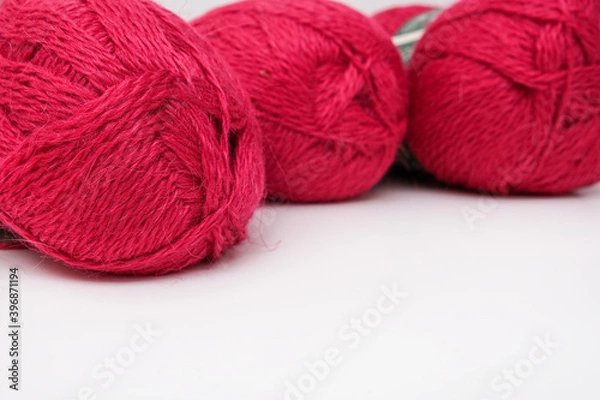 Fototapeta Red pink colorful skeins of yarn close up, fuchsia color woolen yarn for crochet and knitting, hobby and handmade concept, copu space