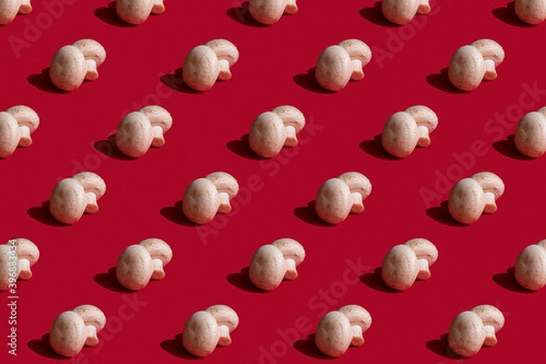 Fototapeta Champignon mushroom pattern on a red background, flat lay. Top view. Vegetarian concept. Food background.