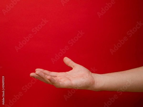 Obraz Female hand shows gesture on a red background.