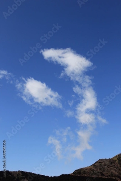 Fototapeta 山の上の青空に、龍が上るような雲がある風景