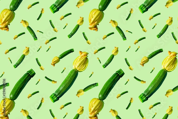 Fototapeta Seamless pattern of young green zucchini with a yellow flower on a green background