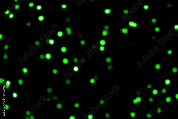 Fototapeta Blurry colored Christmas holiday lights on a black background.