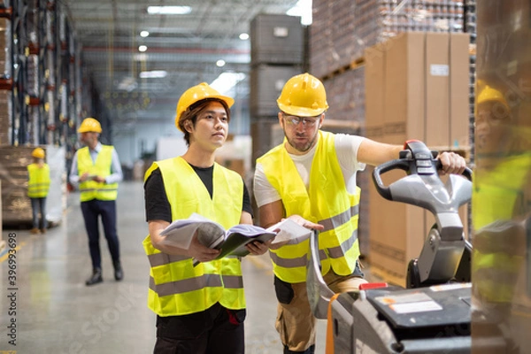 Fototapeta Employees consult while working in the warehouse