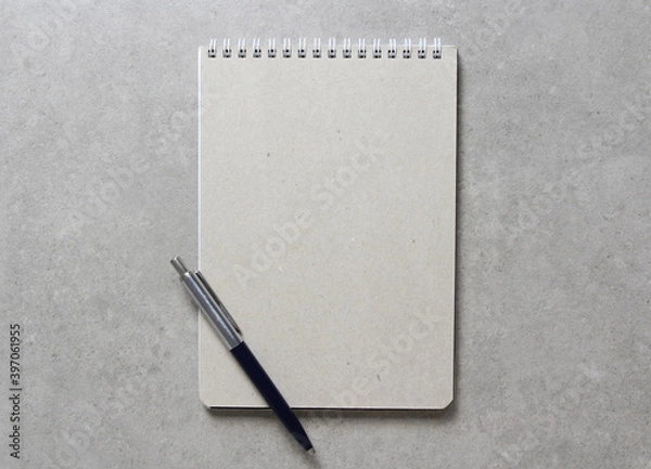 Obraz A spring notebook with a sheet of craft paper A5 with a ballpoint pen on light grey concrete background. Concept of new idea. Empty space for text