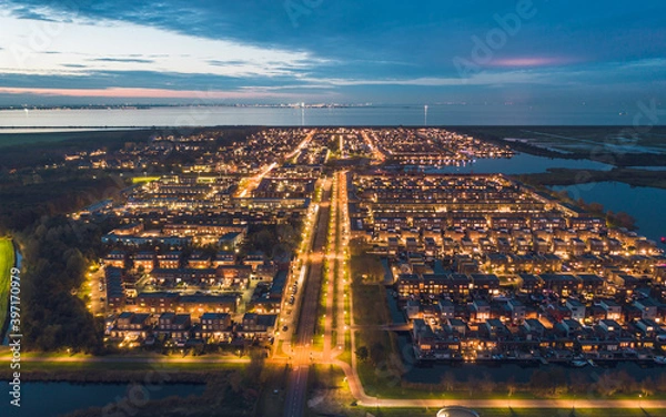 Obraz Modern residential neighbourhood in the city of Almere, The Netherlands, Amsterdam suburb, surrounded by water and nature. Aerial shot at dusk.