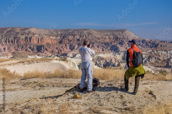 Fototapeta  A man with a camera takes pictures of a beautiful cave complex in Cappadocia. Turkey