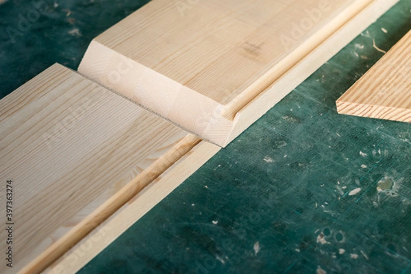 Fototapeta The process of box joints making wooden box in the carpentry workshop. Pinewood boards with bevel cut on the cutting mat.