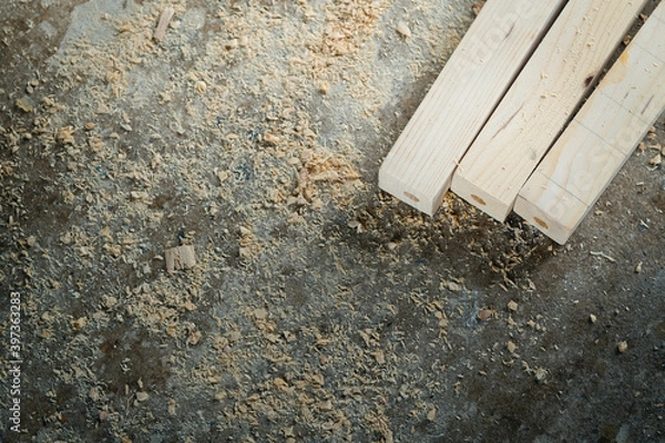 Fototapeta The process of making joints wood lath in the carpentry workshop. Raw pinewood and sawdust on the concrete floor.