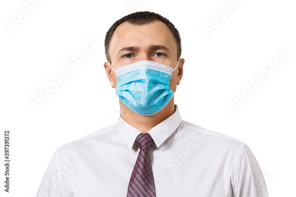 Fototapeta A man in a shirt with a tie and wearing a medical mask on his face isolated on a white background