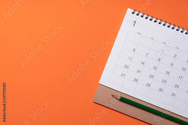 Fototapeta close up of calendar on the orange table background, planning for business meeting or travel planning new year concept