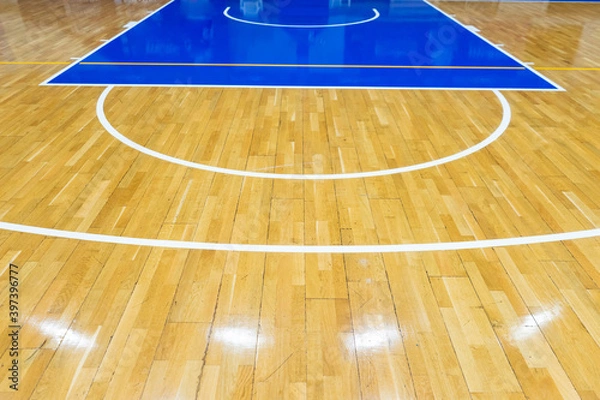 Fototapeta Top view of a part of an empty basketball court. the floor of the sports space is made of wood and painted blue