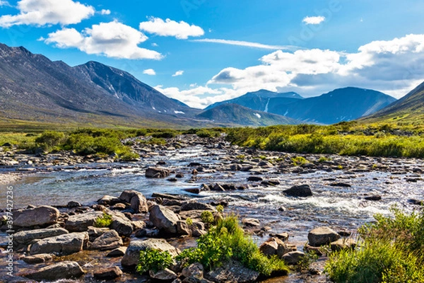 Fototapeta cold stream and mountain range on a summer day