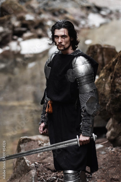 Fototapeta Knight in armor and with a sword. Medieval warrior