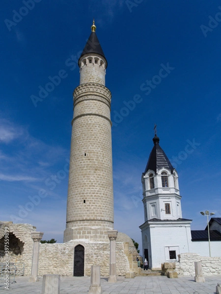 Fototapeta A fusion of two cultures: an Orthodox bell tower and an Islamic minaret in the ancient capital of the Golden Horde. Bolgar, Republic of Tatarstan, Russia
