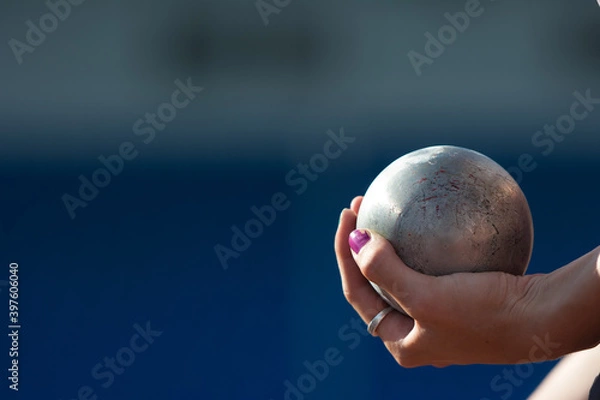 Fototapeta The athlete holds the projectile (shot) in the shot put. Close-up