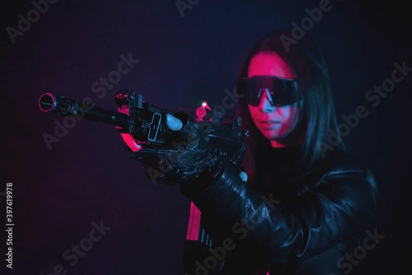 Obraz Futuristic girl soldier with a gun in the smoke on the dark background.