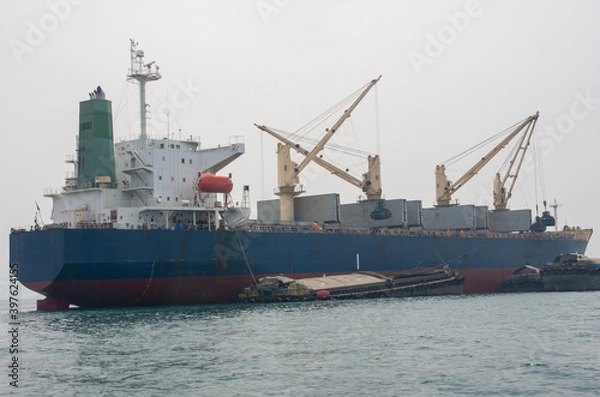 Fototapeta A large container ship sailed in the middle of the sea.