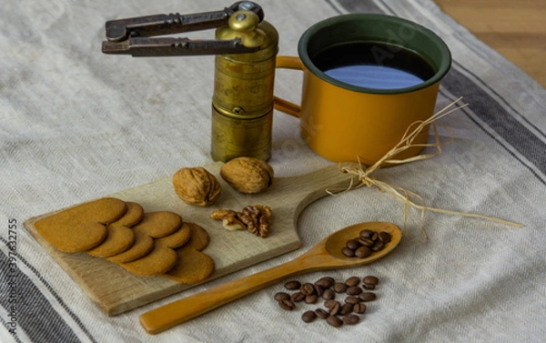 Obraz A cup of coffee, a coffee grinder, walnuts and cookies