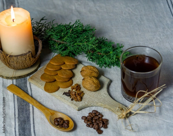 Obraz A Christmas table setting with candle, juniper branch, cup of coffee, a coffee grinder, walnuts and cookies