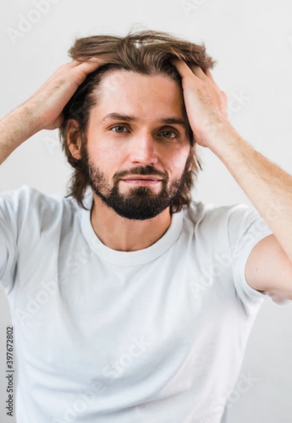 Fototapeta Close up of a cute young man messing with his hair. Skin Care.