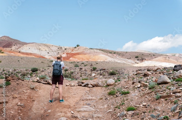 Obraz Young Tourist Girl and Summer Sandy Hills Landscape. Travel Mountain location of Popular Attraction. View of beautiful nature Desert on Cloudy Sky Background